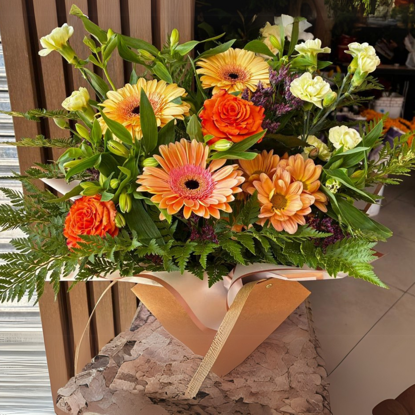 Cartera con mix floral de la estacion, acompañada con follaje, limonium entre otros toques de Flores Silvestres