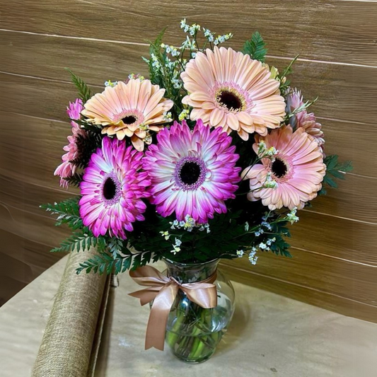 Florero de 10 Gerberas, con follaje silvestre, toques de limonium.