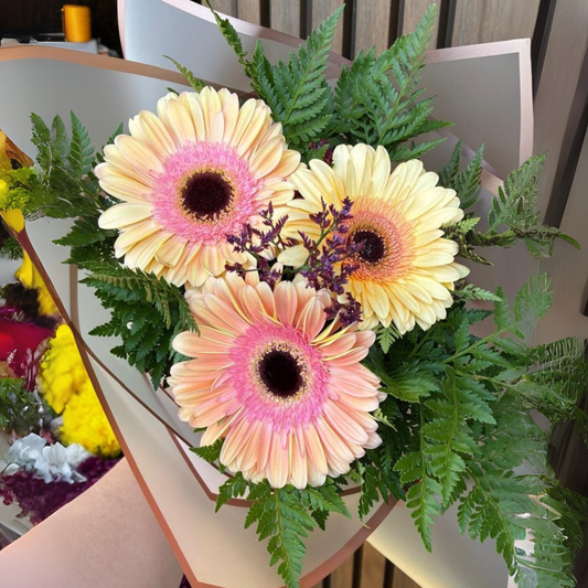 Ramo de 3 Gerberas, con follajes silvestres y toques de limonium.